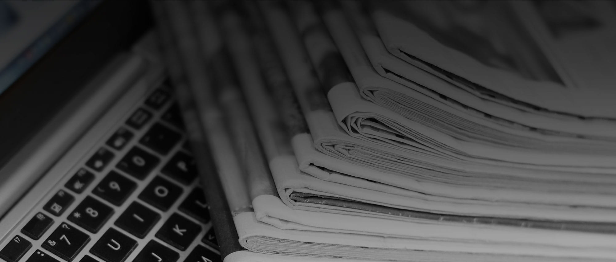 Newspaper stack on an unfolded notebook.